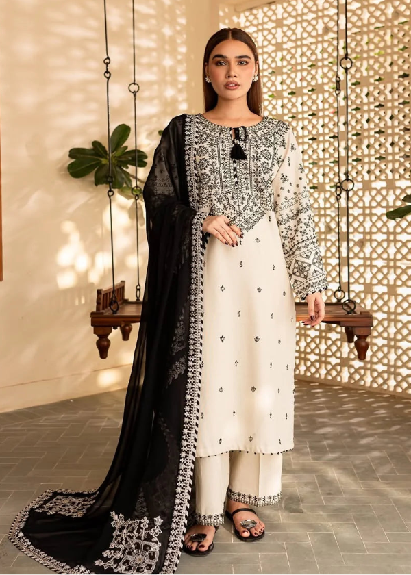 Woman in a traditional outfit standing in a decorative indoor setting with plants and a lattice wall.