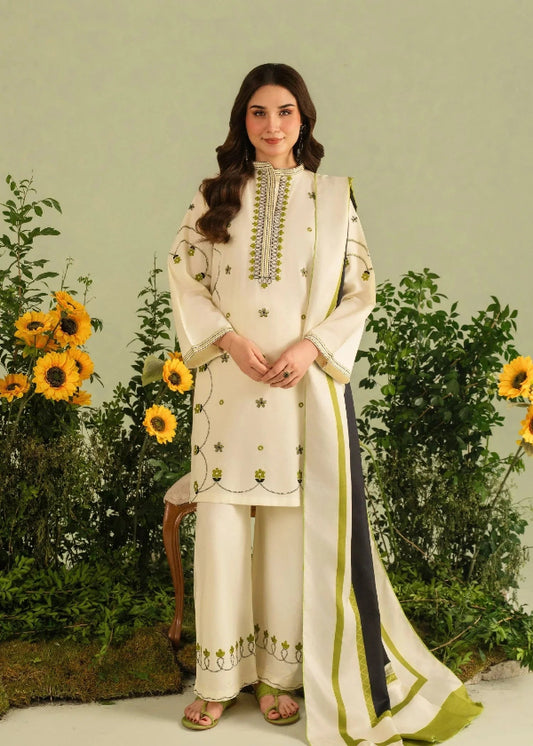 Woman in a cream embroidered outfit standing in front of sunflowers and greenery